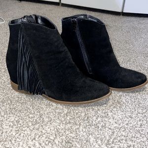 Black ankle boots with fringe.